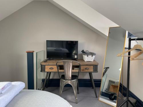 布萊頓霍夫的住宿－Jewel of Kemptown - luxury townhouse, sleeps 9，一间卧室配有书桌、电视和椅子