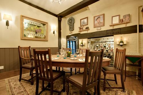 a dining room with a wooden table and chairs at The George Hotel & Brasserie, Cranbrook in Cranbrook