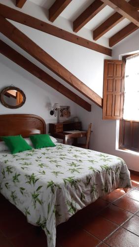 a bedroom with a large bed with green pillows at Posada la Torre in Serdió