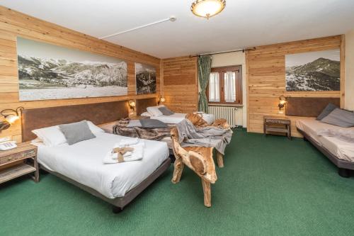 a bedroom with two beds and a couch at Hotel Gran Baita in Sauze dʼOulx