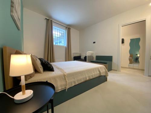 Un dormitorio con una cama y una mesa con una lámpara. en Appartamento Anagiulia, en Bardolino