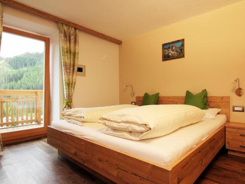 a bedroom with two beds and a large window at Villa Hilde in San Cassiano