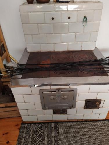 a stove with white tiles on top of it at Gospodarstwo Agroturystyczne w Borszycach in Wola Pękoszewska