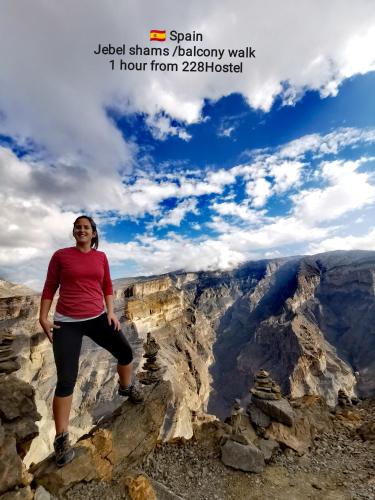 a woman standing on a cliff at the grand canyon at 228Hostel in Al Ḩamrāʼ