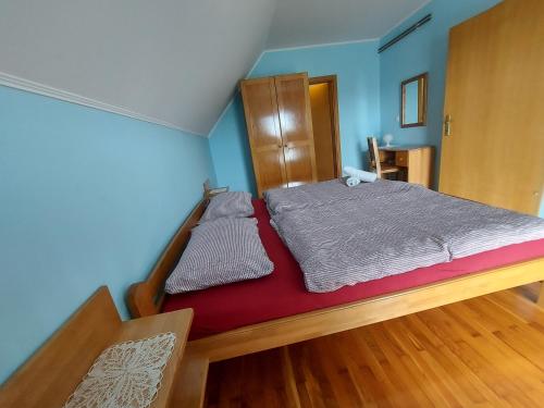 a small bed in a room with blue walls at Masnec Tourist Farm in Miljana