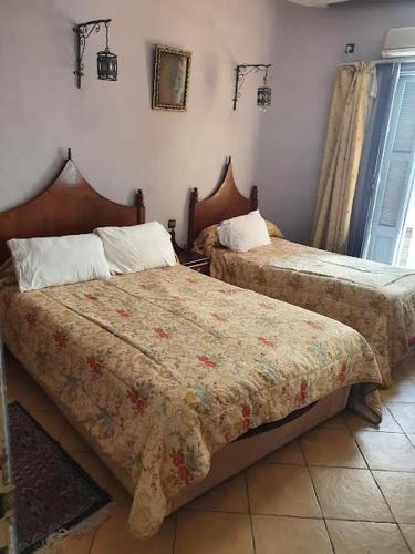 a bedroom with two beds in a room at HOTEL DU LOUVRE in Casablanca