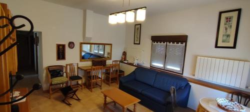 a living room with a blue couch and a table at CASA DE LOS ABUELOS in Ortigosa del Monte