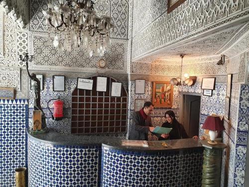 een man en een vrouw die aan een balie in een restaurant staan bij HOTEL DU LOUVRE in Casablanca