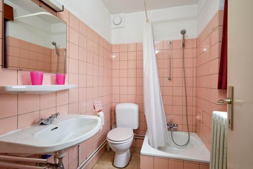 une salle de bains rose avec lavabo et toilettes. dans l'établissement Noordzee 10/30, à Blankenberge