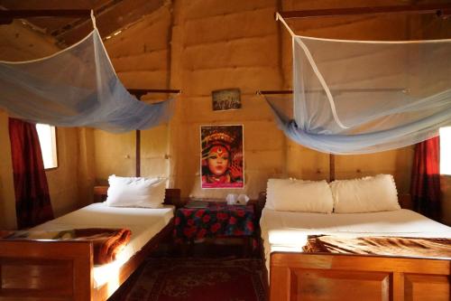 a bedroom with two beds with mosquito nets in it at Forest Hideaway Resort Pvt Ltd in Bhurkīā