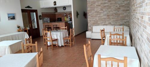 uma sala de jantar com mesas e cadeiras brancas em Hotel Grove em O Grove