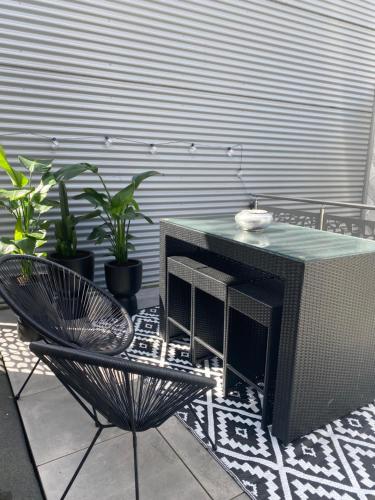 a patio with a table and a chair and plants at New appartement centre de Spa avec parking privé in Spa