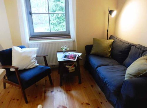 a living room with a blue couch and a table at Biohof Buschmühle in Königsfeld