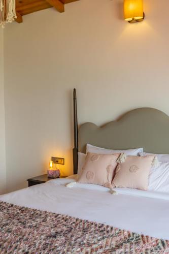 a bed with white sheets and pink pillows at Seclude Ramgarh Willows in Rāmgarh