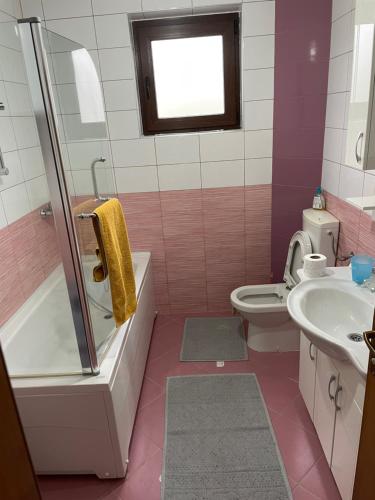 a bathroom with a tub and a toilet and a sink at Porodicna kuca za odmor Kovaci in Zavidovići