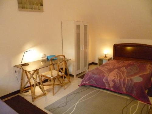 a bedroom with a bed and a desk and a table at La Gilberdiere in La Rochelle-Normande