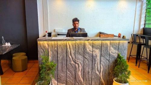 un uomo seduto a una scrivania con un portatile di Olive By Tej Hotel And Resorts a Darjeeling