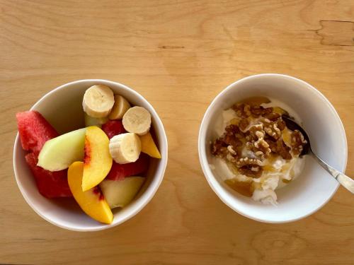 two bowls of fruit and cereal on a wooden table at Nuevo Vista in Kavos