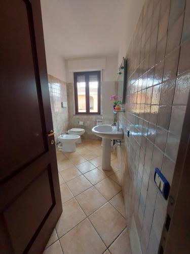a bathroom with two toilets and a sink at Affittacamere Center Room in Tortolì