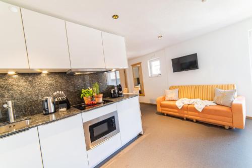 a kitchen and living room with a couch in a room at Aparthotel Hochland GmbH in Nauders