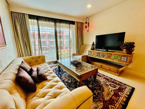 Una sala de estar con un sofá y un televisor de pantalla plana. en Baan Marakesh Hua Hin, en Hua Hin