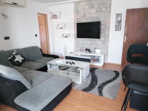 een woonkamer met een bank en een tv bij Tea in Povljana