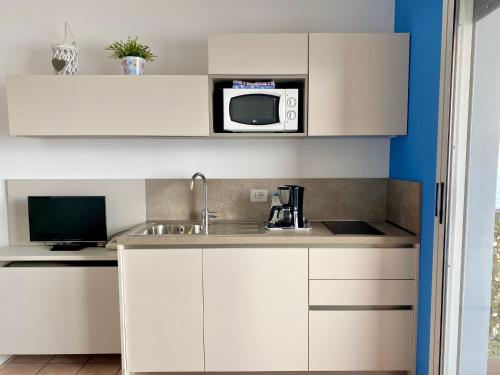a kitchen with a sink and a microwave at Residence Casa e Vela in Oggebbio