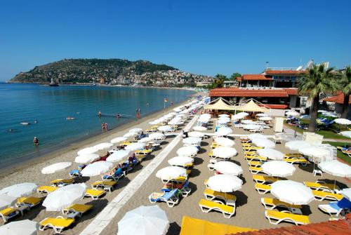 a bunch of umbrellas and cars on a beach at Panorama Hotel - All Inclusive in Alanya
