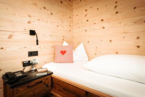a bedroom with a bed in a wooden room at Gästehaus Mathies in Mittelberg
