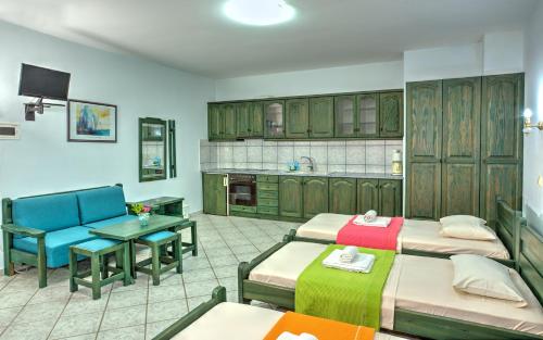 Hotel Zeus في كاريستوس: غرفة بثلاث اسرة وطاولة ومطبخ
