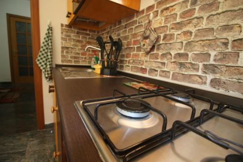- une cuisine avec des plaques de cuisson et un mur en briques dans l'établissement Casa di Luce LightHouse, à Reggio de Calabre