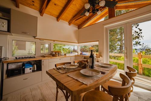 kuchnia z drewnianym stołem i oknami w obiekcie Tu Apart En Bariloche 16 w mieście Bariloche