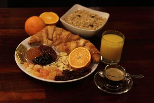 a table with a plate of breakfast food and orange juice at The Bryson Hotel in London