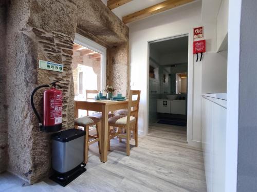 a kitchen and dining room with a table and a fire extinguisher at Cantinho do Sossego in Vila Nova de Cerveira