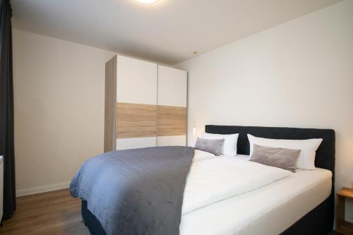 a bedroom with a large white bed with pillows at Marin Hotel Sylt GmbH in Westerland (Sylt)