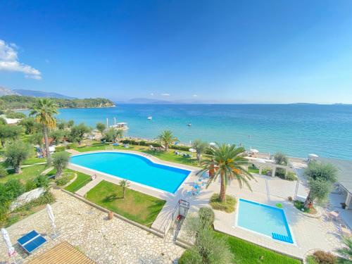 an aerial view of a swimming pool and the ocean at Elea Beach Hotel in Dassia