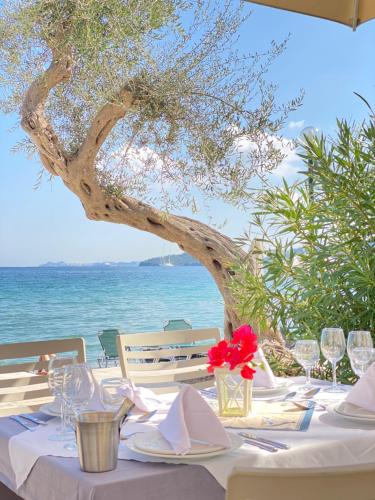 a table with a white table cloth and wine glasses at Elea Beach Hotel in Dassia