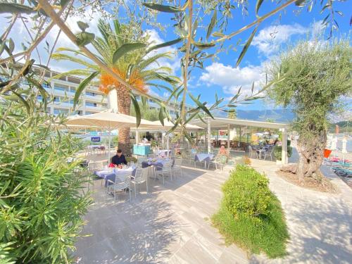 a person sitting at a table under an umbrella at Elea Beach Hotel in Dassia