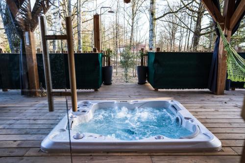a jacuzzi tub on a wooden deck at Charmante Cabane dans les arbres avec jacuzzi et sauna in Boismorand