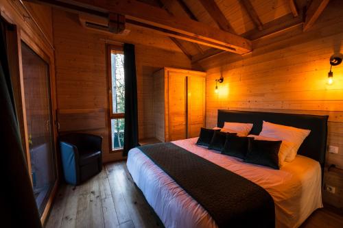 Tempat tidur dalam kamar di Charmante Cabane dans les arbres avec jacuzzi et sauna