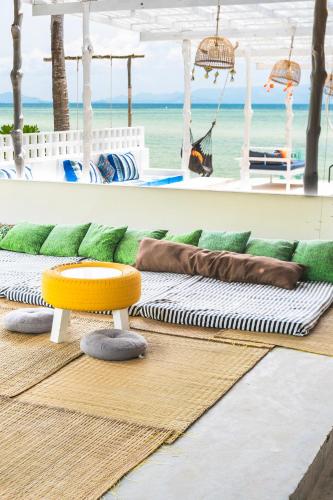 a room with a couch and a table and the beach at Chantaramas Beach Resort Koh Phangan in Baan Khai
