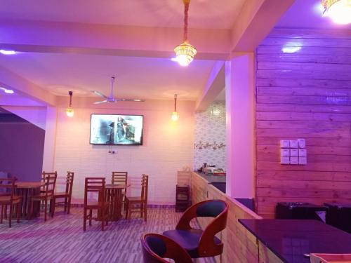 a restaurant with tables and chairs and purple lighting at Chibuba Airport Accommodation in Dar es Salaam