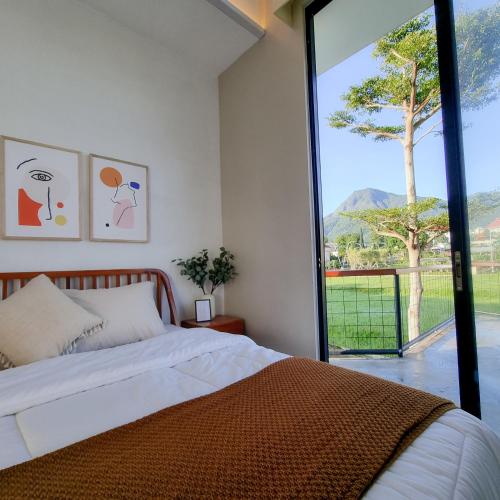 Un dormitorio con una cama y una ventana grande. en Casa Terra, en Batu