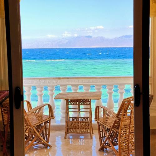 a table with chairs and a view of the ocean at Lucky palace Dahab in Dahab