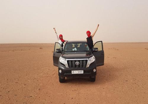 two men standing in the back of a truck in the desert at Sahara Relax Camps in Zagora