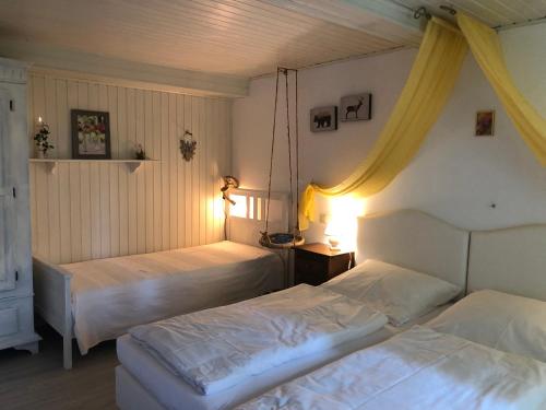 two beds in a bedroom with two lamps on at Romantikmühle Heartlandranch in Krummenau