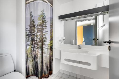 a white bathroom with a sink and a shower curtain at Danhostel Vejle in Vejle
