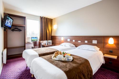 2 Betten in einem Hotelzimmer mit einem Tablett mit Essen in der Unterkunft Brit Hotel Rennes Le Castel in Rennes