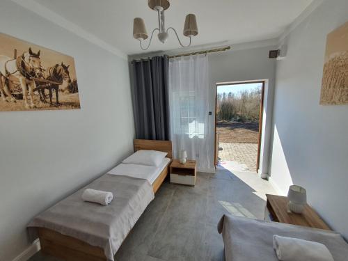 クウォツコにあるPokoje w parku i folwarku przy Pałacu Ławicaのリビングルーム(ベッド2台、窓付)