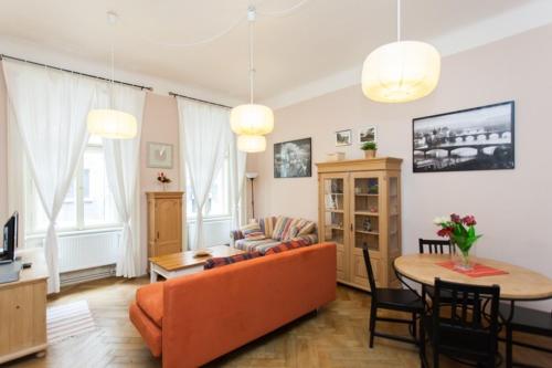 - un salon avec un canapé orange et une table dans l'établissement Andrews Centre Apartment, à Prague